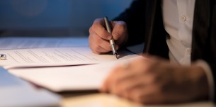 Businessman working late signing a document or contract